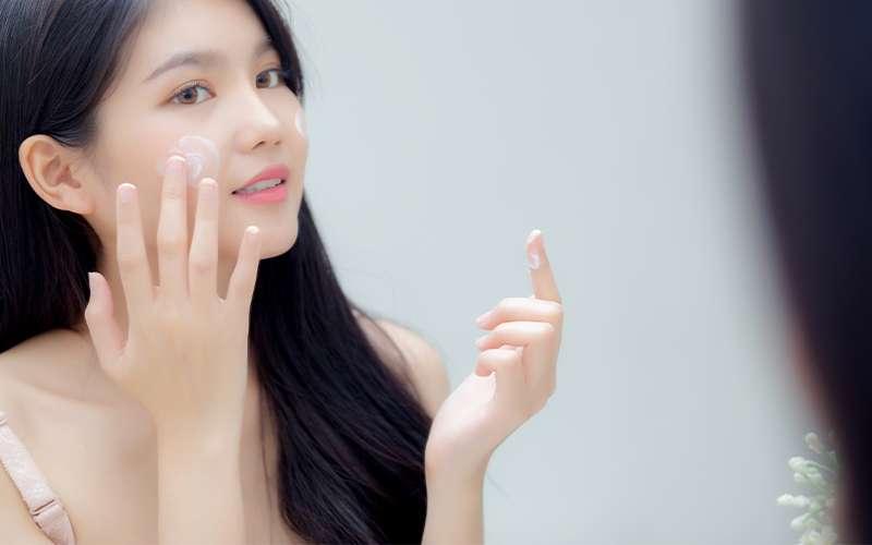 Woman Apply Cream On Face