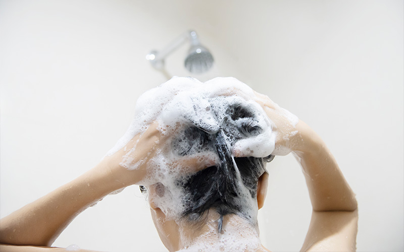 Woman is Washing her Hair with Shampoo