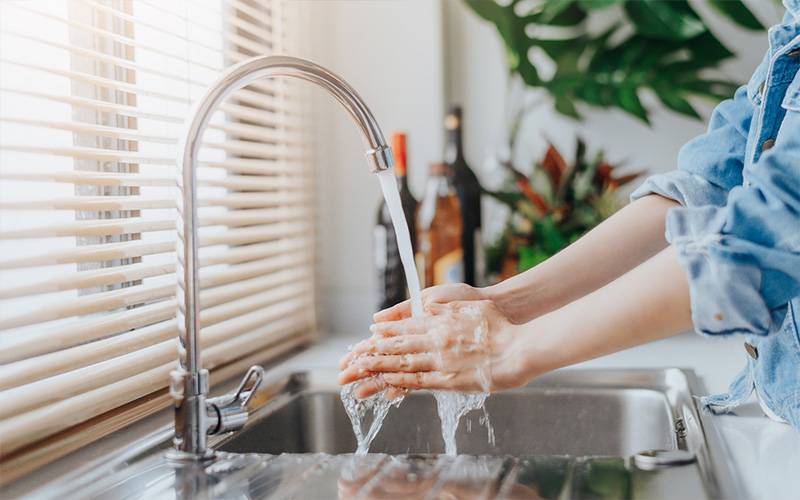 Woman washing hands in sink